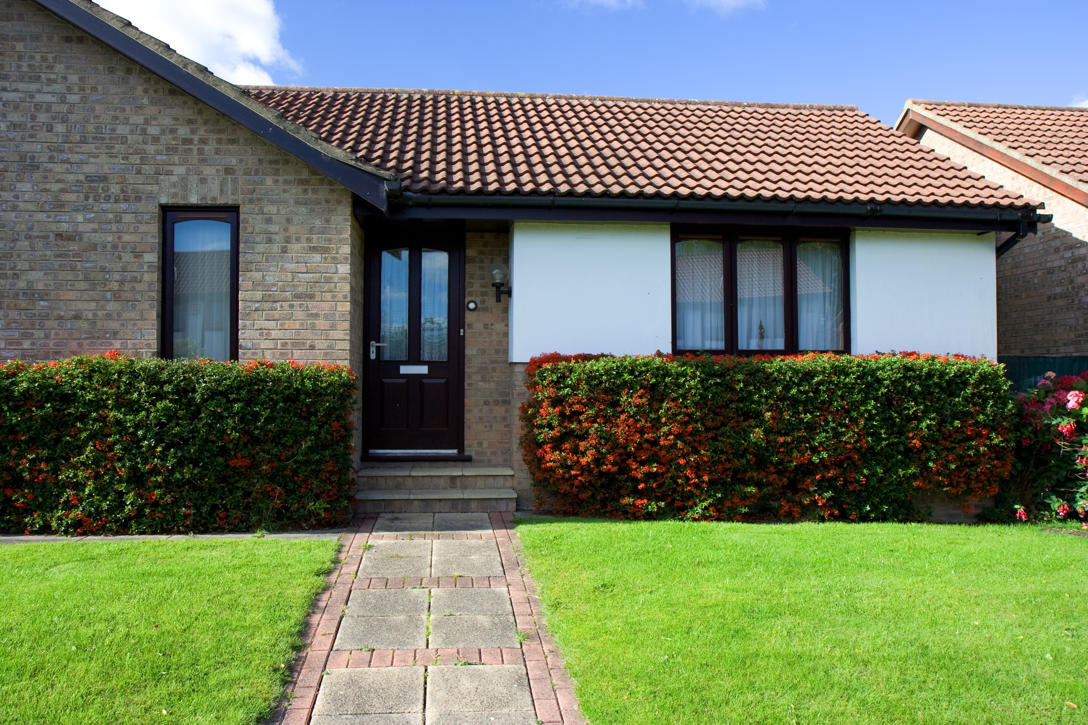 Well maintained bungalow with neatly trimmed hedge and lawn