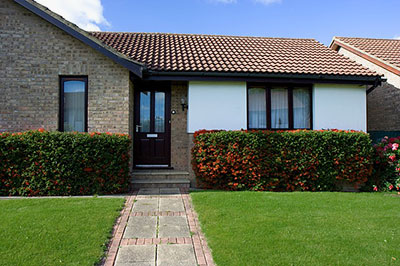 Well maintained bungalow with neatly trimmed hedge and lawn